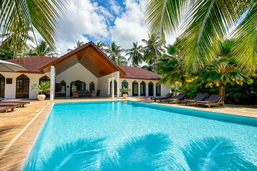 Pool flanked by the villa's arched windows