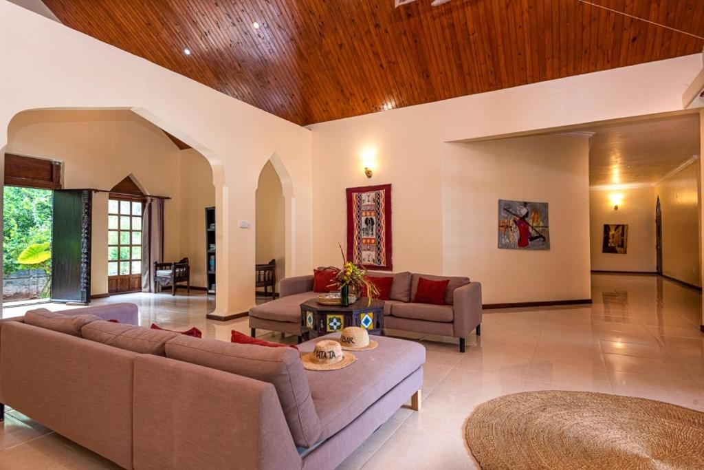 Spacious lounge with paired sofas and African textile art